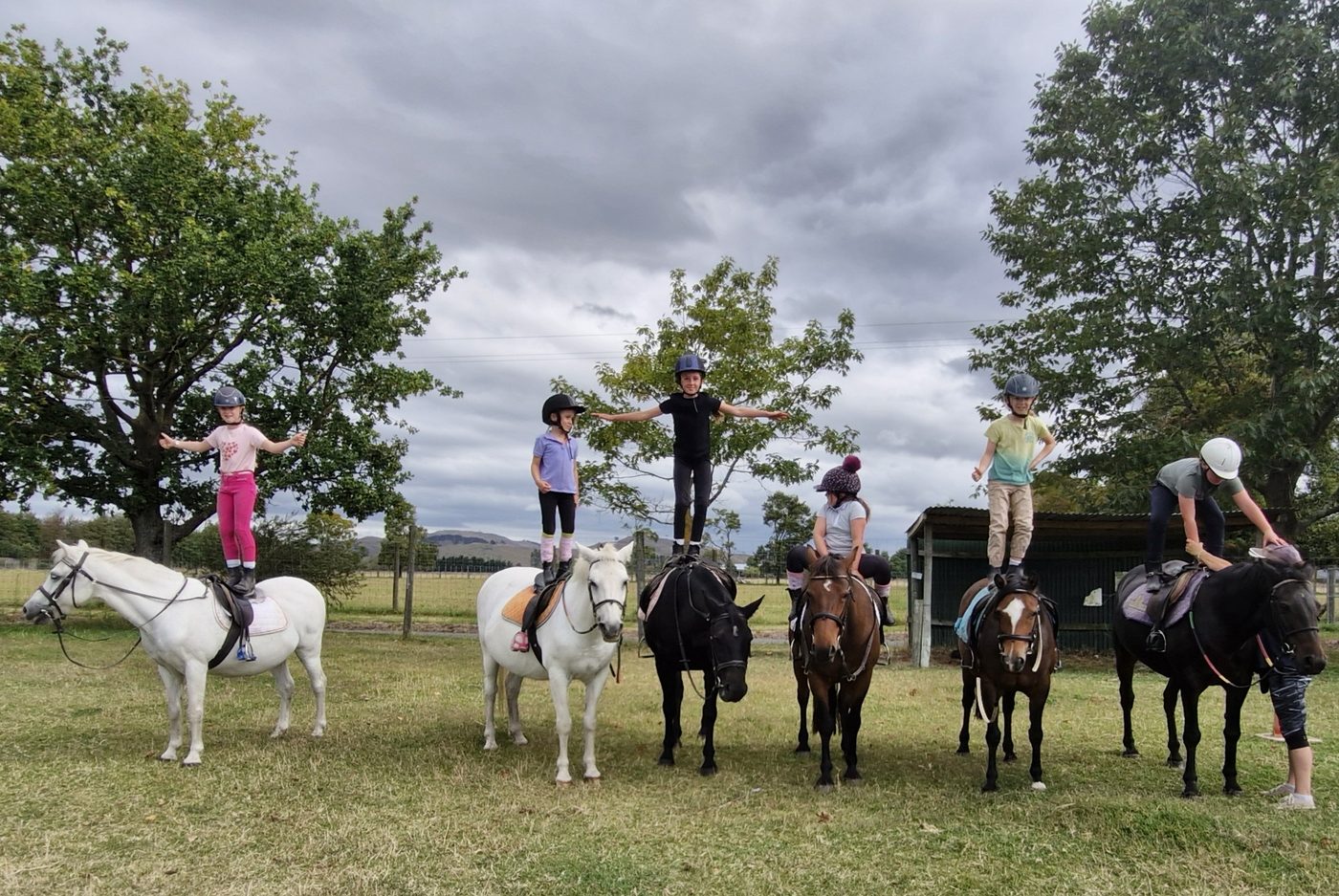 Riders confidently standing on their ponies